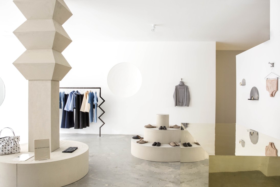 Interior of No Order Market retail space with minimalist design, cream walls, geometric display fixtures, and clothing racks.