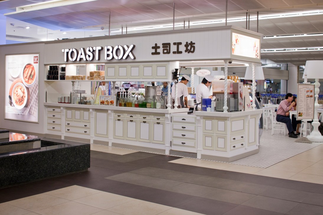 Toast Box outlet at Changi airport with cream-colored counter and signage in English and Chinese.