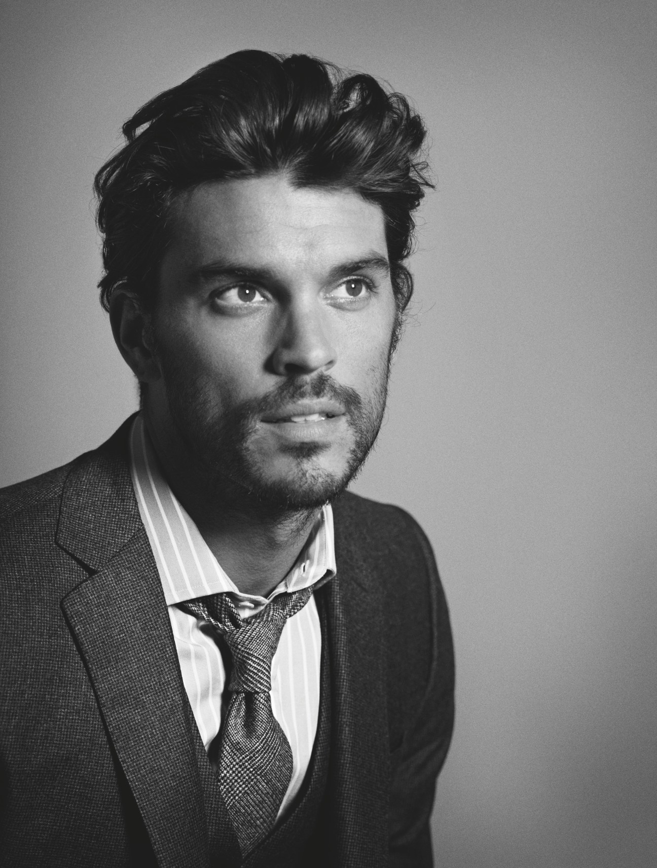 Man in three-piece suit and tie by Hackett with shirt by E. Tautz in black and white portrait.