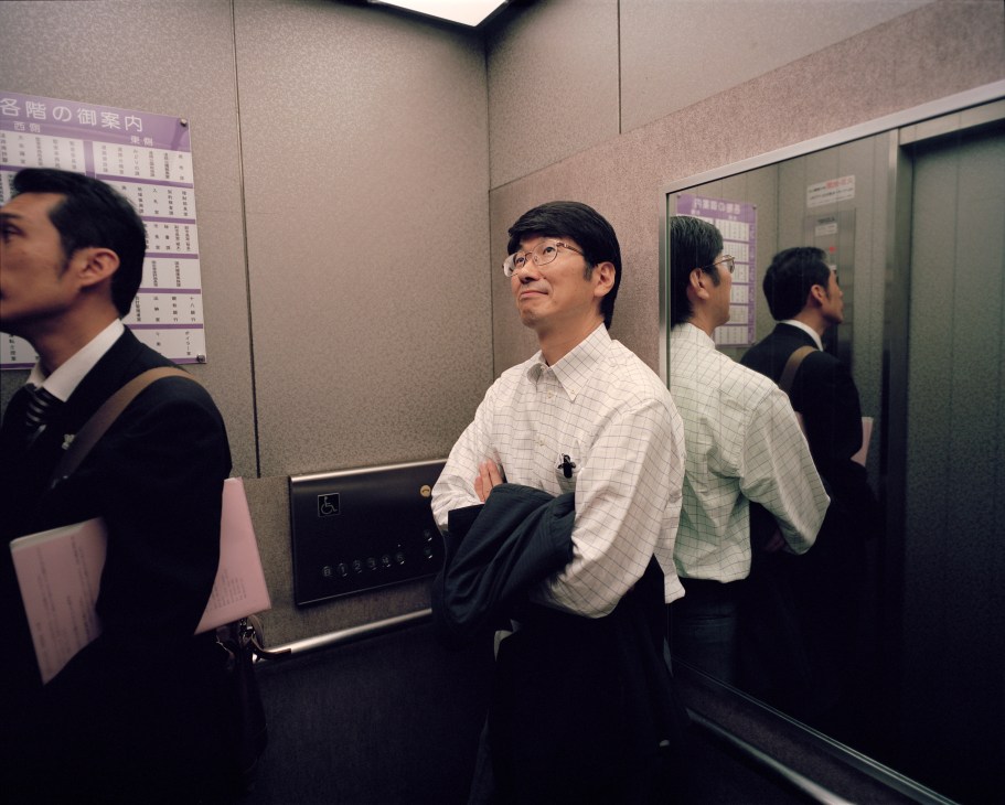Tomihisa Taue, Mayor of Nagasaki, stands in a city hall lift with colleagues.