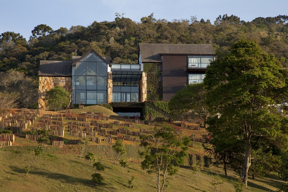 Botanique Hotel and Spa nestled in rainforest with contemporary architecture and large windows overlooking the landscape.