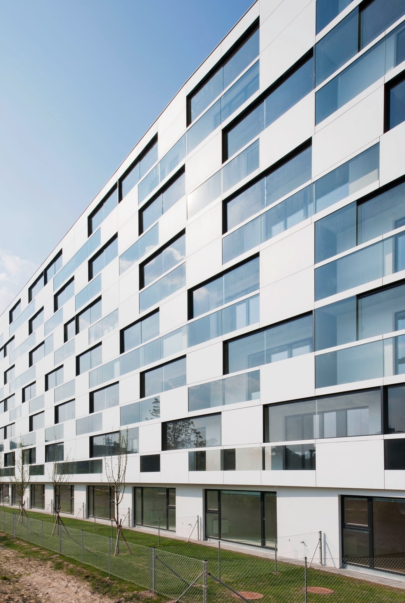 Simply 11 social housing block in Vienna with white cement fibre façade and regular window pattern.