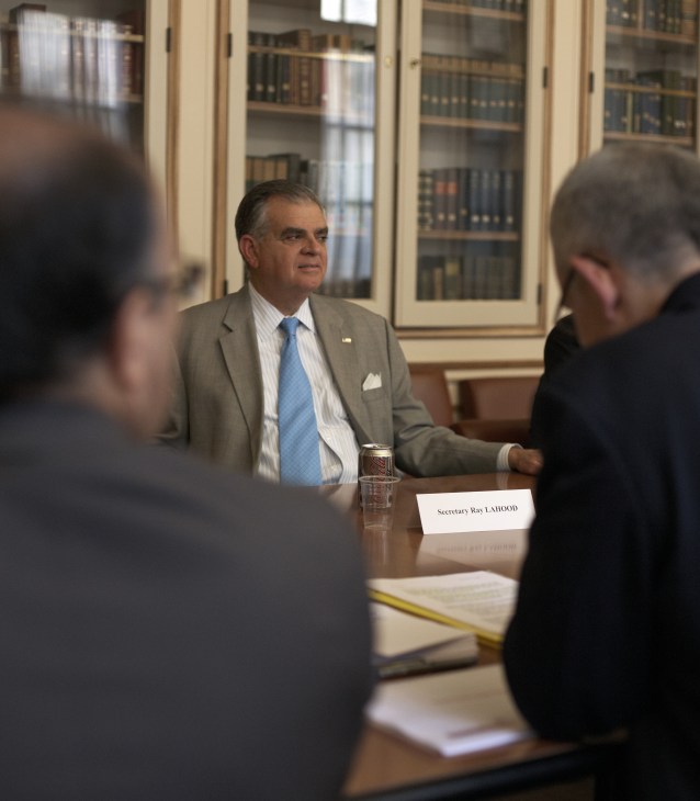 Ray LaHood seated at a table with a nameplate during a meeting with French rail officials at the US Embassy in Paris.