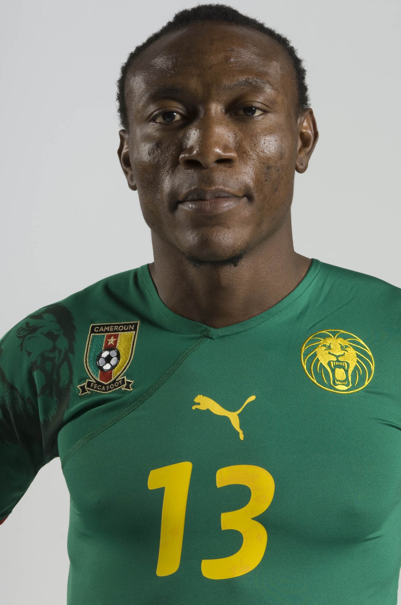 Cameroon footballer Somen Tchoyi wearing Puma green jersey with lion emblem and number 13