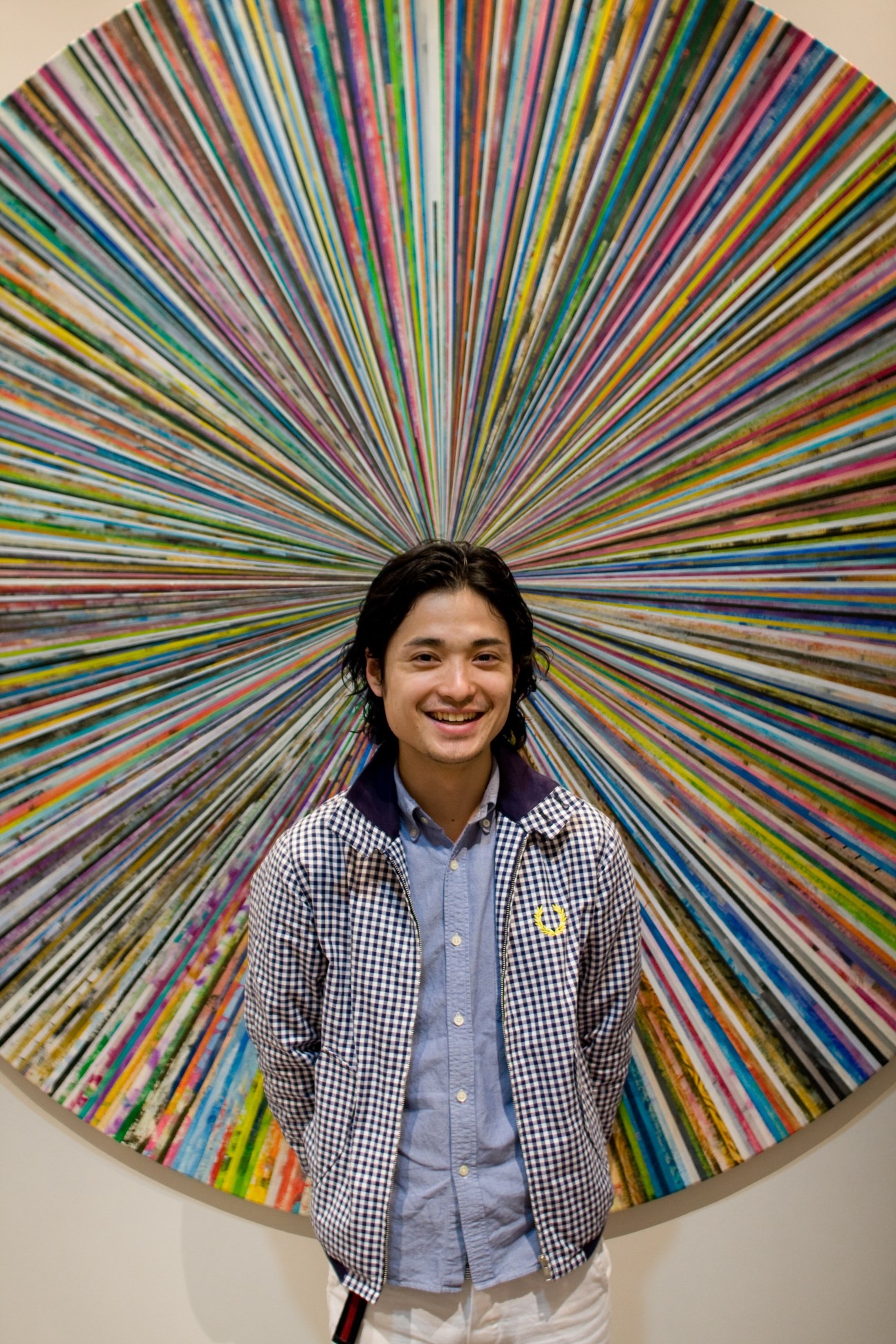 Staff member Ebihara Ken at Tomorrowland's new Aoyama store in Tokyo, standing in front of a colorful radial installation.