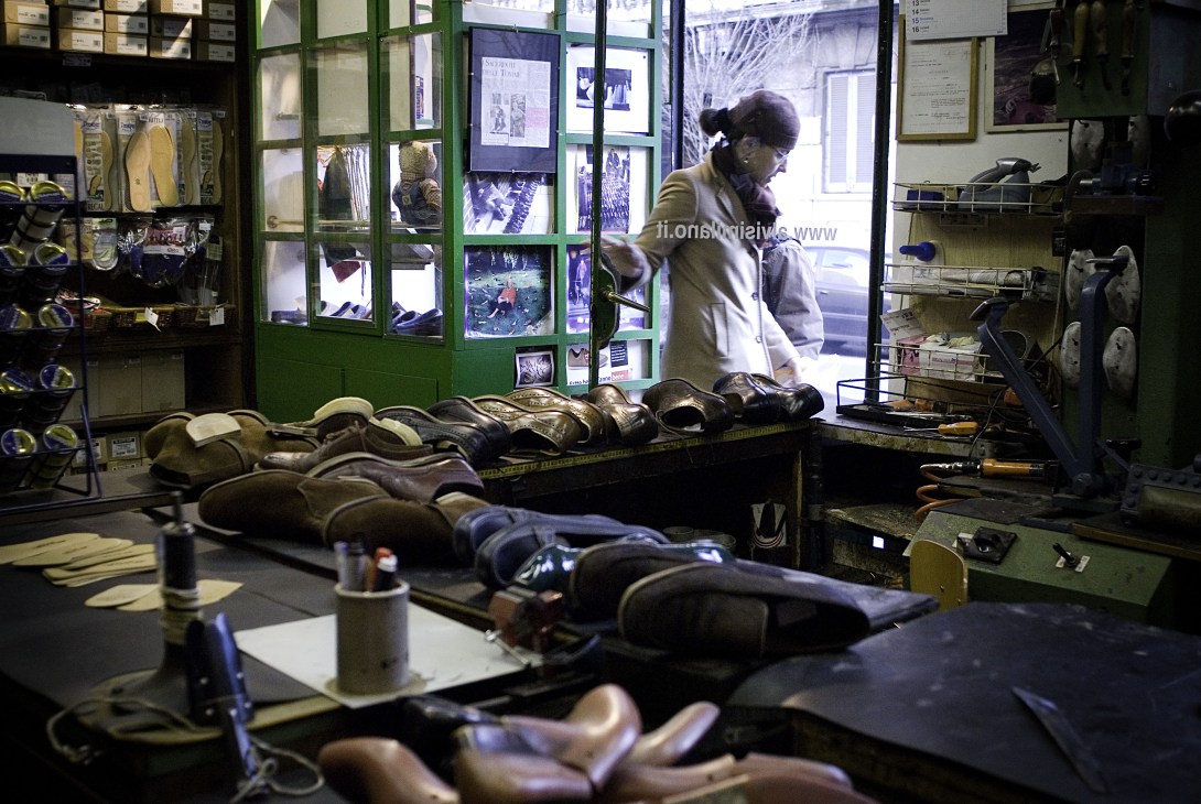 Ermanno Alvisi's Milan cobbler shop with rows of shoes awaiting repair on the work table.