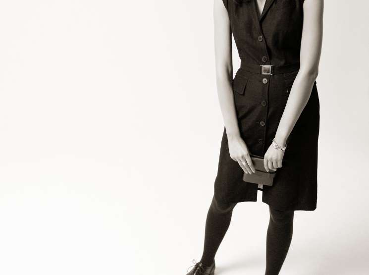 Model wearing sleeveless René Lezard dress with belt, Church's shoes, and holding Smythson diary.