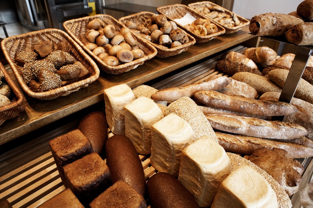 Display of various breads and pastries in wicker baskets at Andersen bakery.