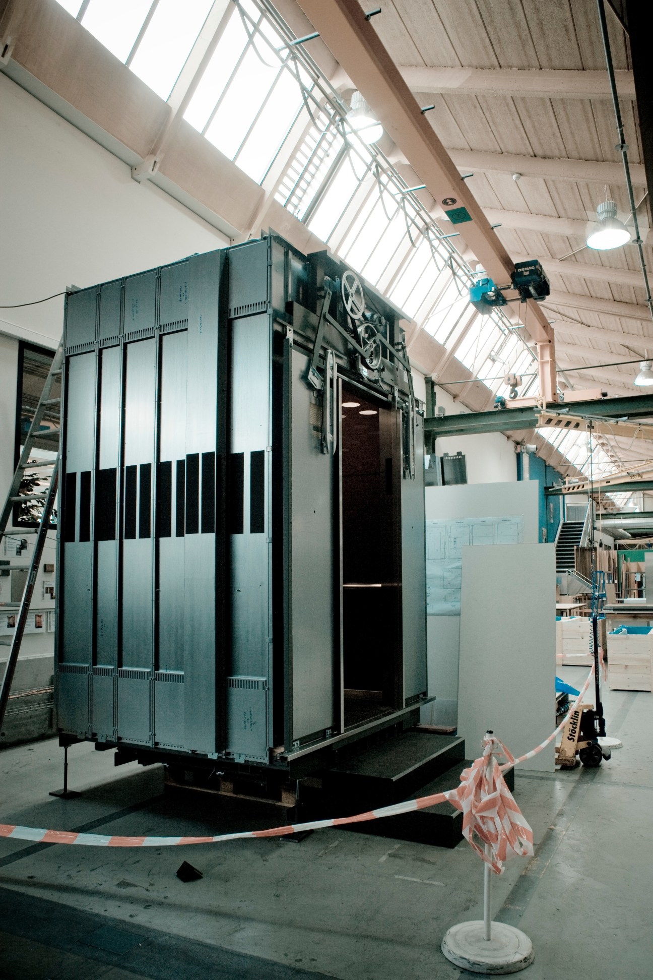 Custom-made elevator cabin with striped design in Schindler factory under construction.