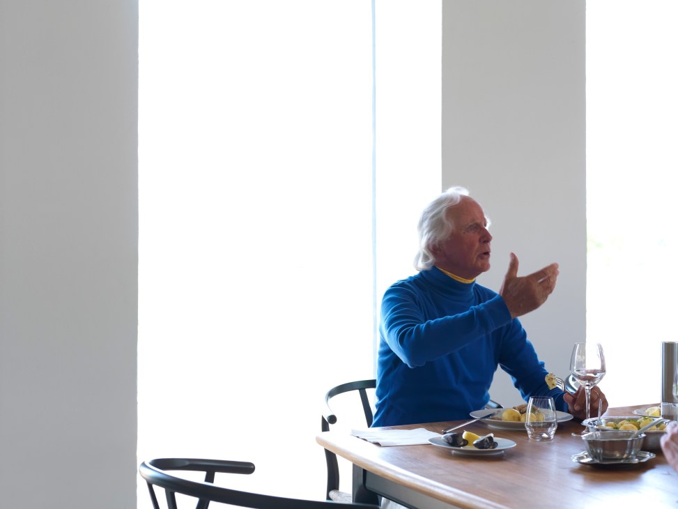 Jacob Jensen gestures while speaking at a dining table in his design studio