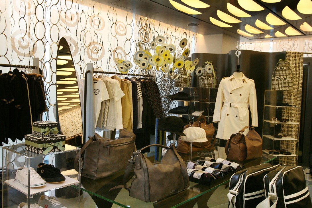 Interior of 10 Corso Como Seoul store with clothing displays, handbags, and modern geometric wall design.