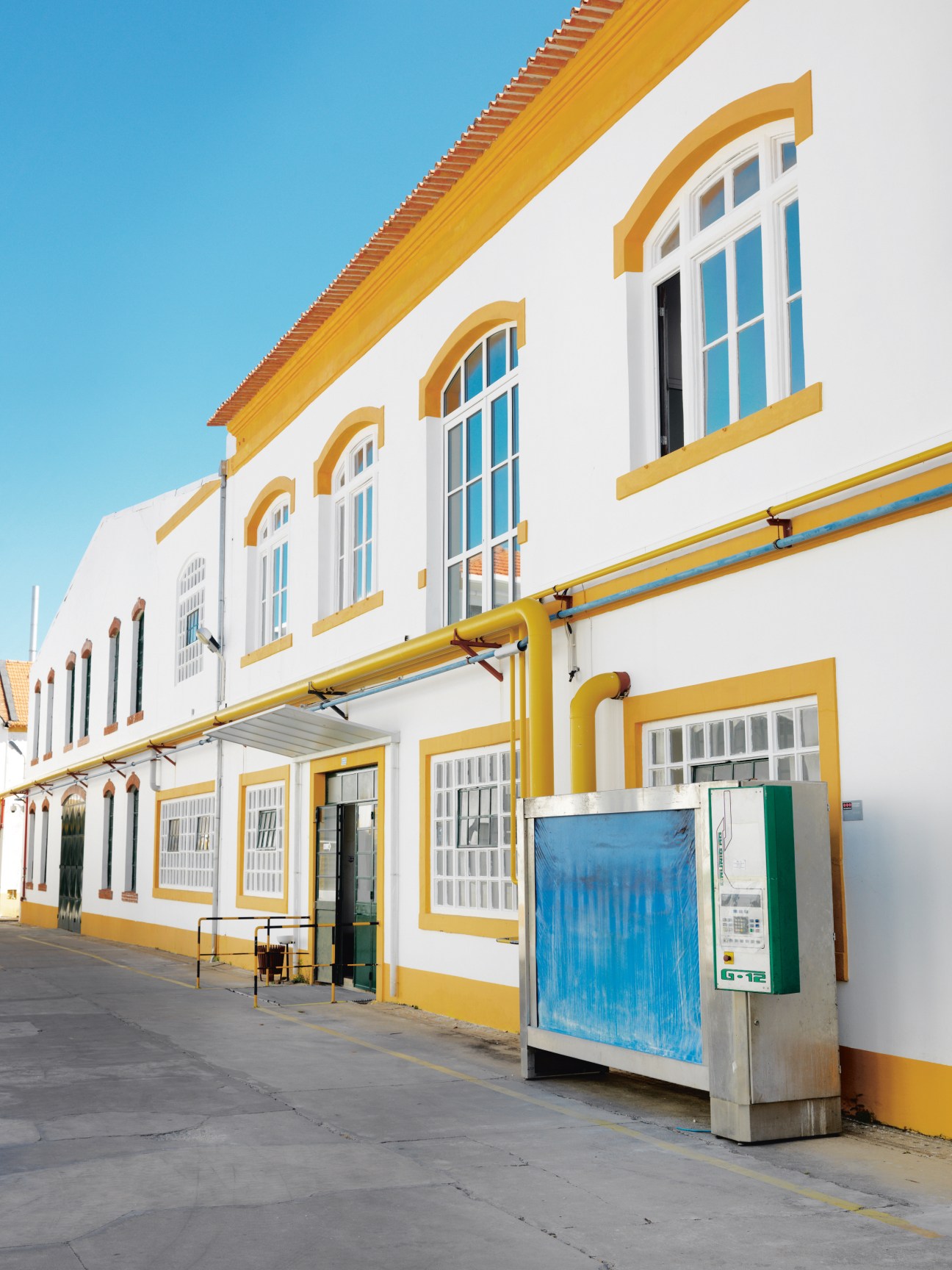 Vista Alegre porcelain factory exterior with whitewashed stone walls, yellow-painted architectural details and arched windows.