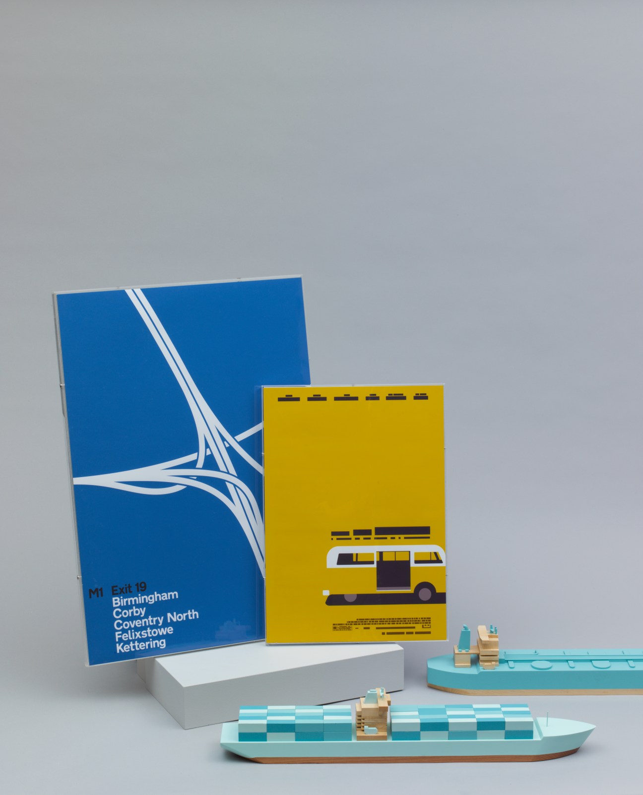 Papa Foxtrot wooden ships and Print-Process posters displayed with blue and yellow design prints and turquoise wooden toy boats.