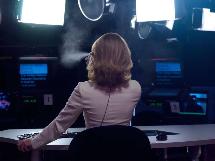 Russia Today presenter Anastasia Haydulina applies hairspray at her desk in the broadcast studio.