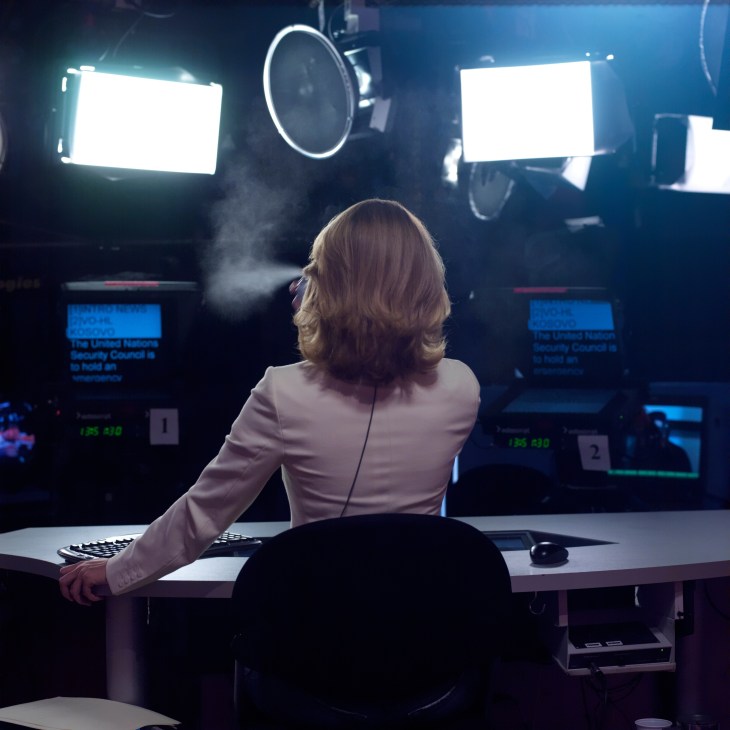 Russia Today presenter Anastasia Haydulina applies hairspray at her desk in the broadcast studio.