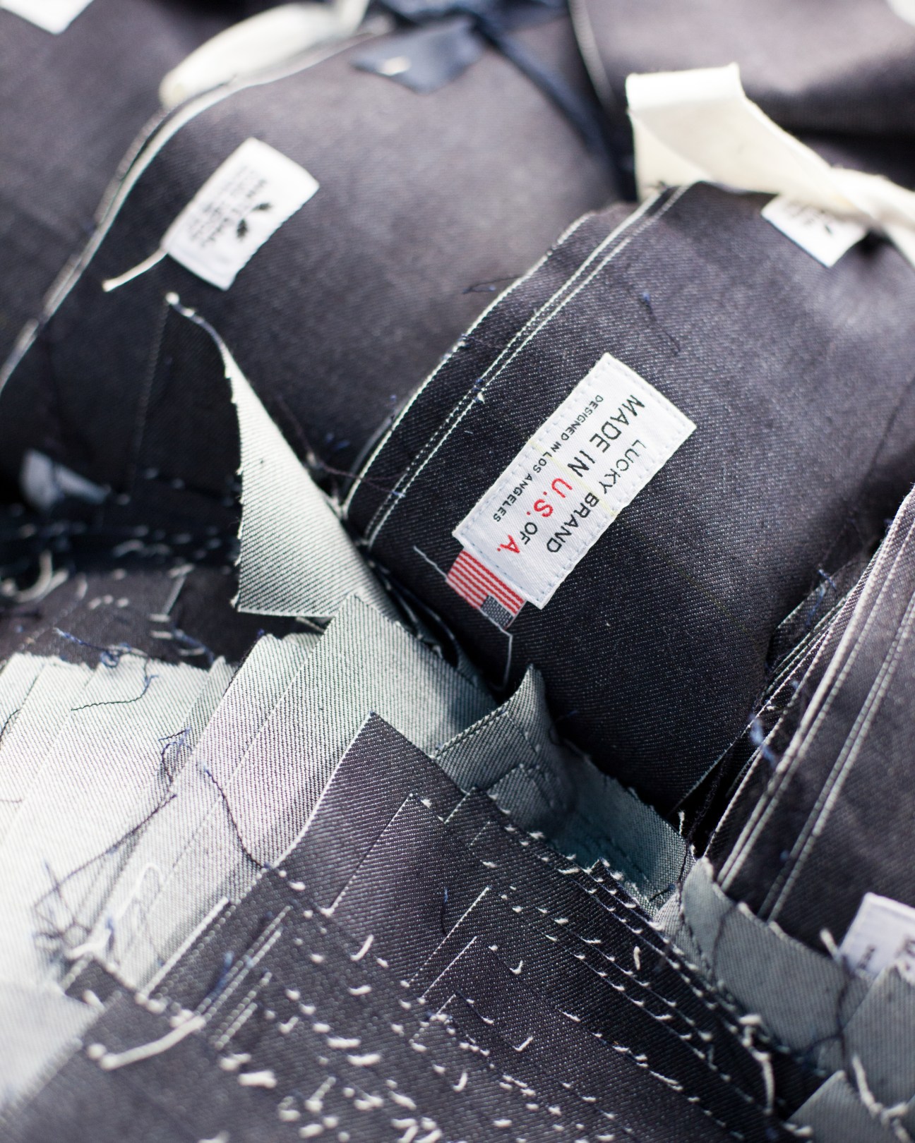 Close-up of 'USA Made' label on black denim fabric with white stitching.