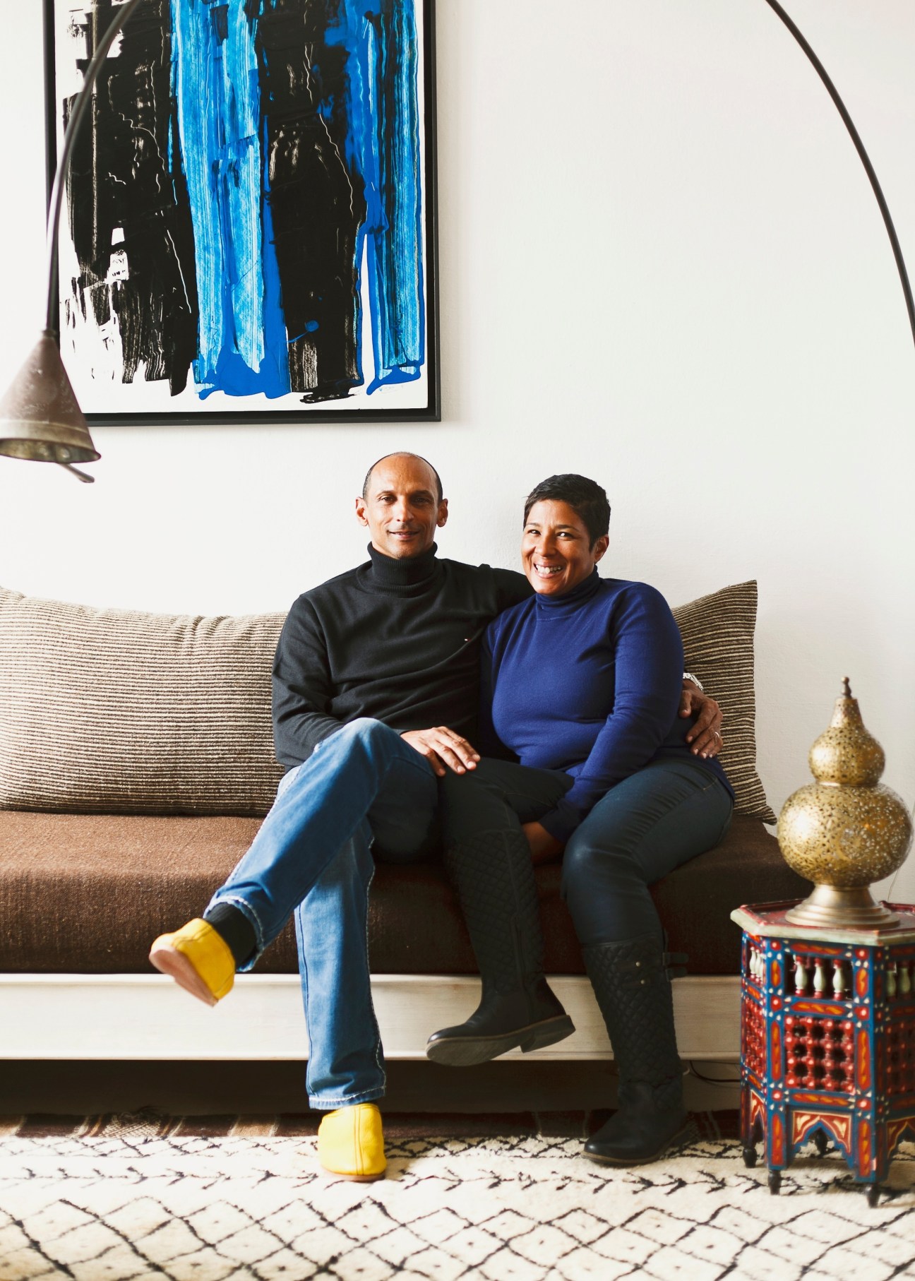 David and Odile Neguede sit together on a striped sofa in their Tangier home.