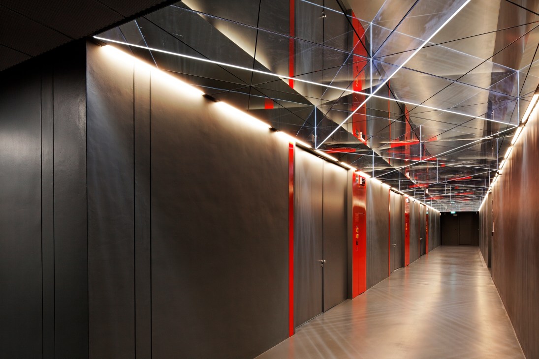Interior corridor of Singapore Freeport with red doors, steel walls and modern lighting.