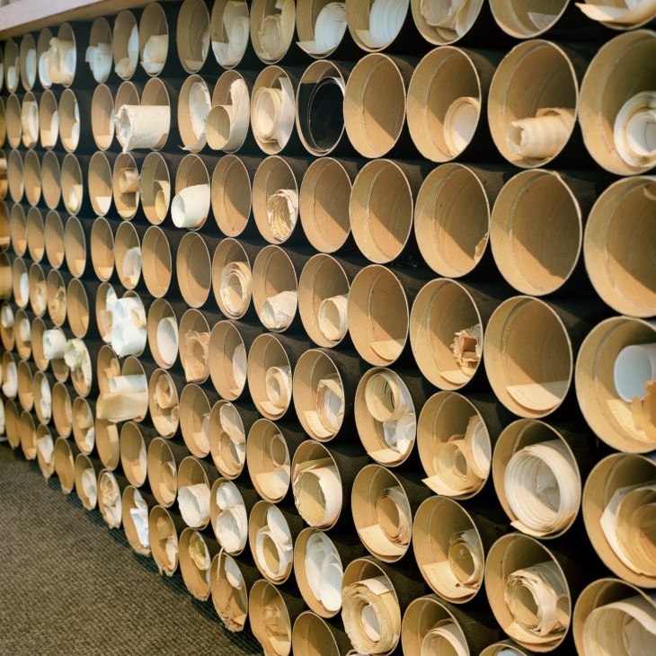 Wooden bowls and containers stacked in organized rows beneath a worktop in Diffrient's studio.