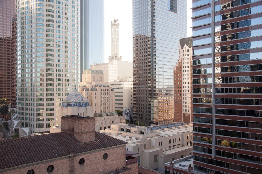 Downtown Los Angeles skyline with historic and modern buildings including a white tower with ornate details.