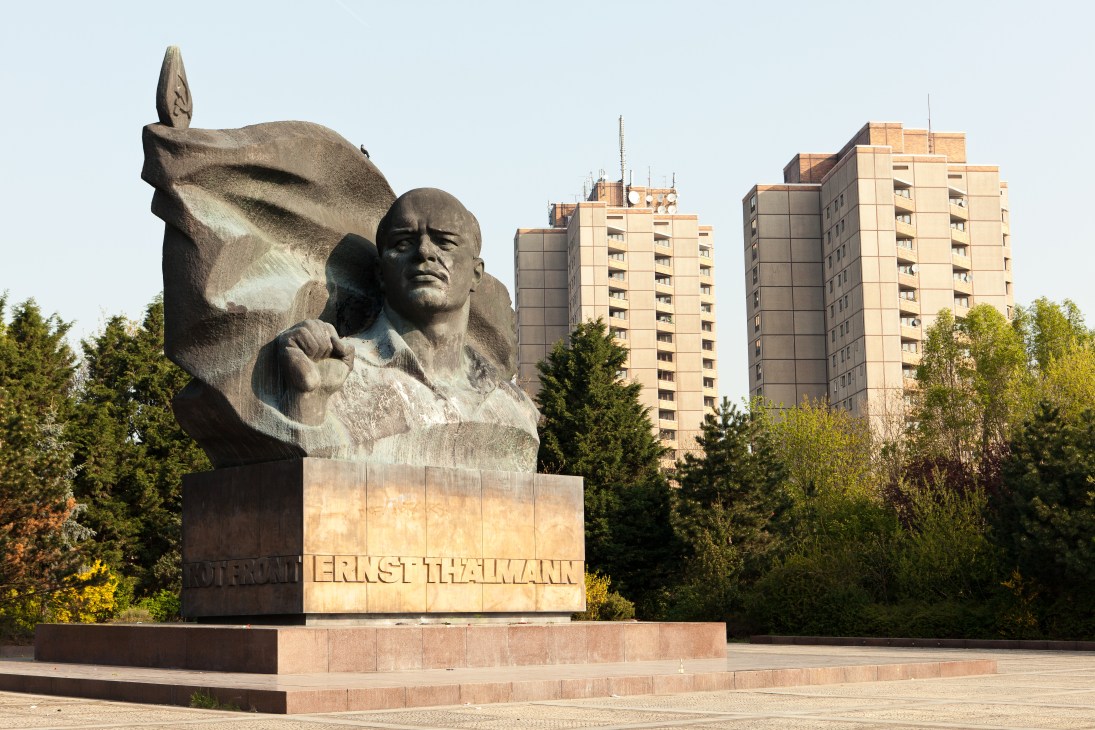 Ernst Thälmann memorial statue with prefabricated apartment buildings in the background in Berlin.