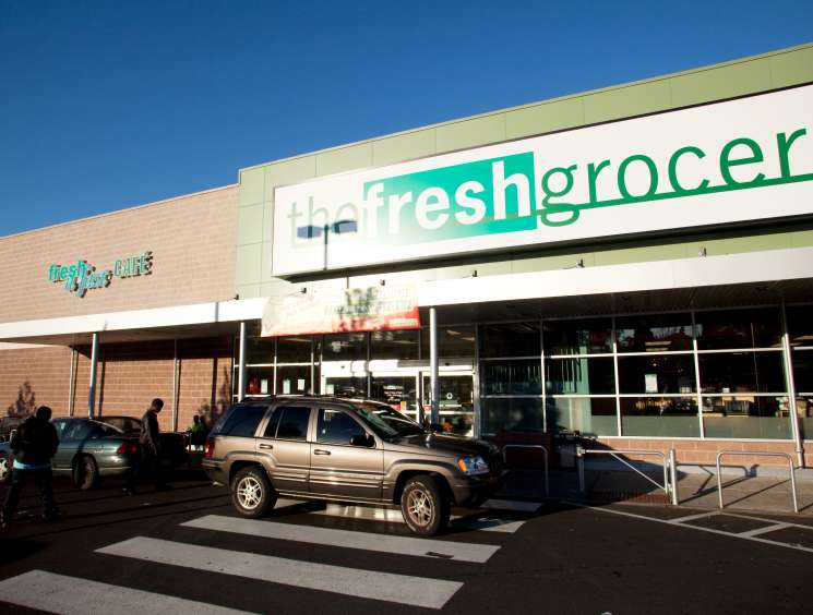 The Fresh Grocer storefront in Pennsylvania with turquoise and green signage on a brick building.