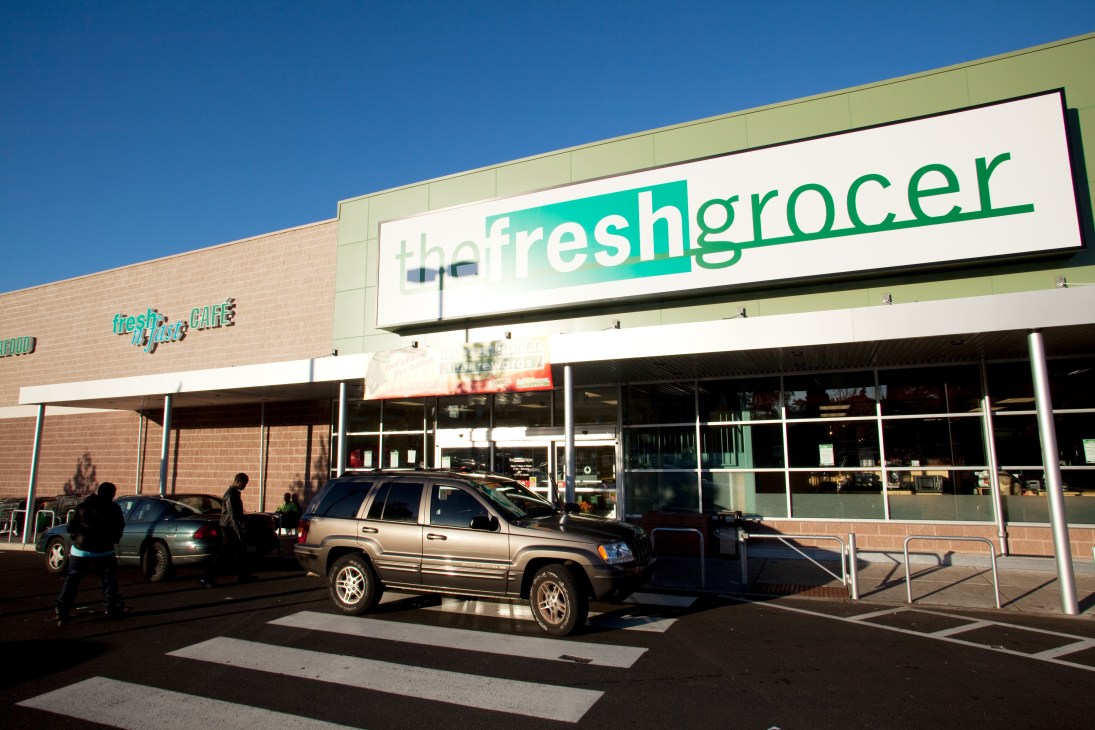 The Fresh Grocer storefront in Pennsylvania with turquoise and green signage on a brick building.