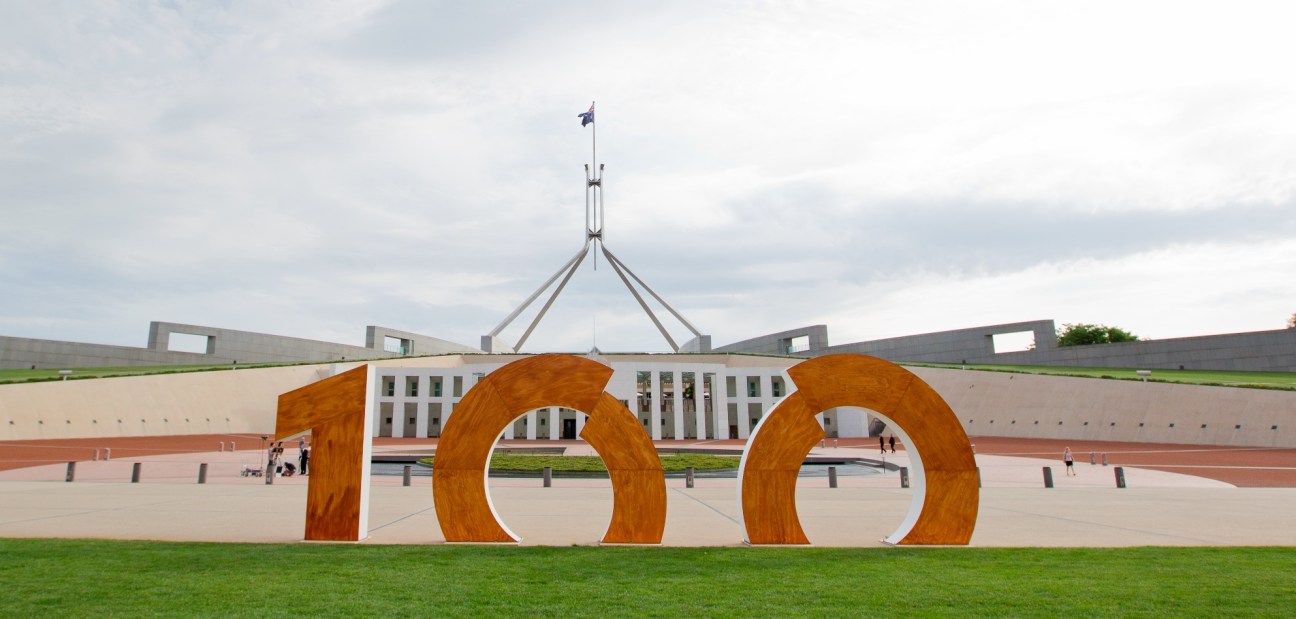 Large golden numerals "100" displayed in front of Parliament House in Canberra, marking the city's centenary.
