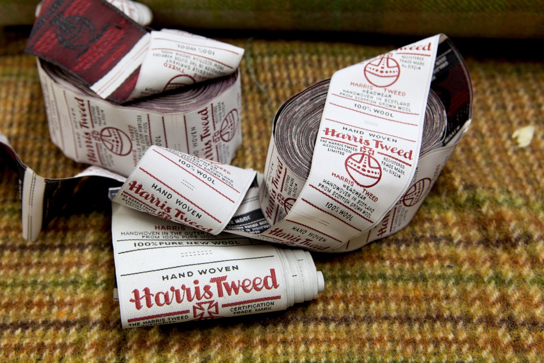 Harris Tweed authentication labels and ID numbers on rolled fabric samples.