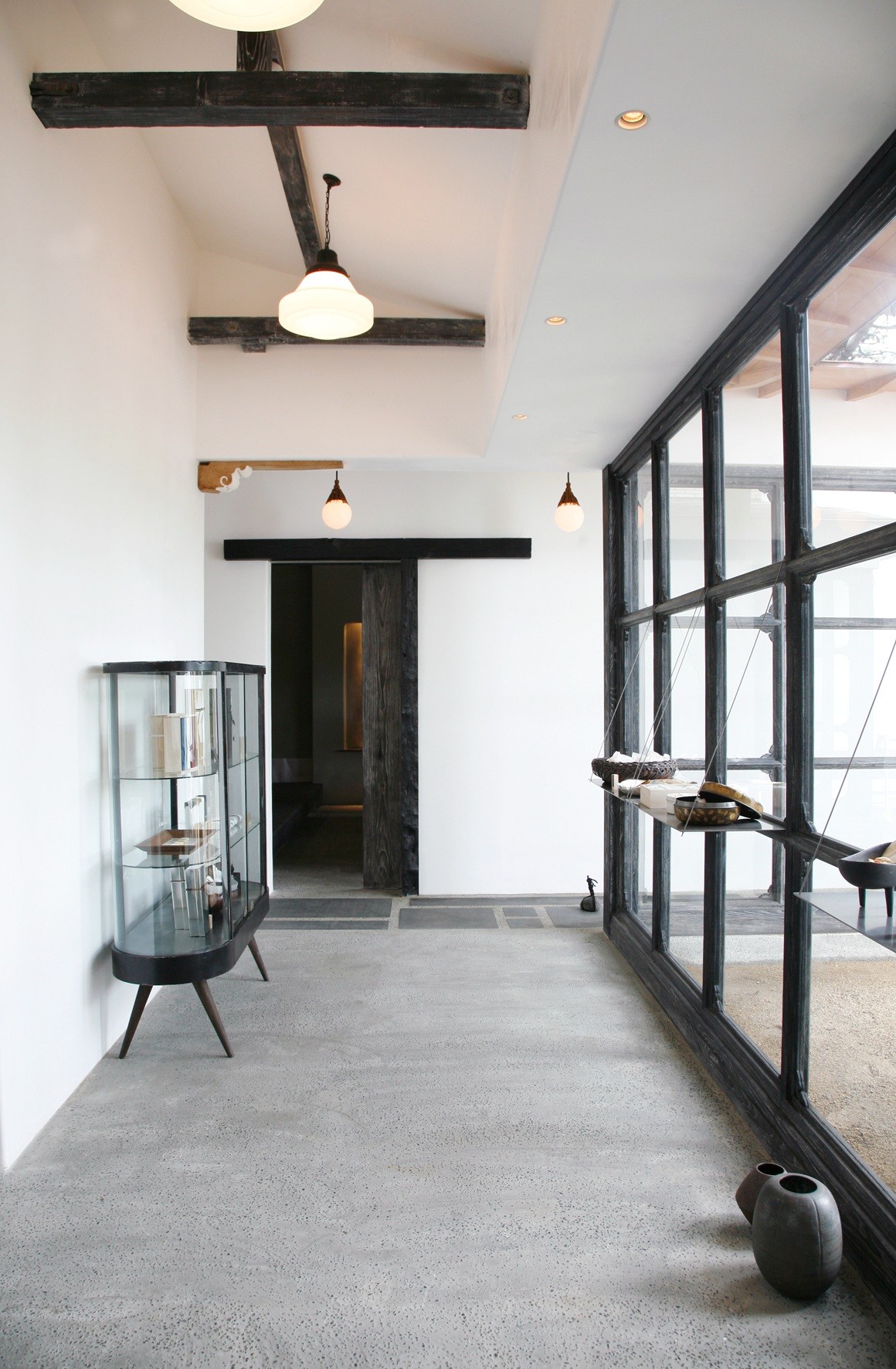 Interior of Baishinka Tokyo café with dark wooden beams, pendant lights and large windows.