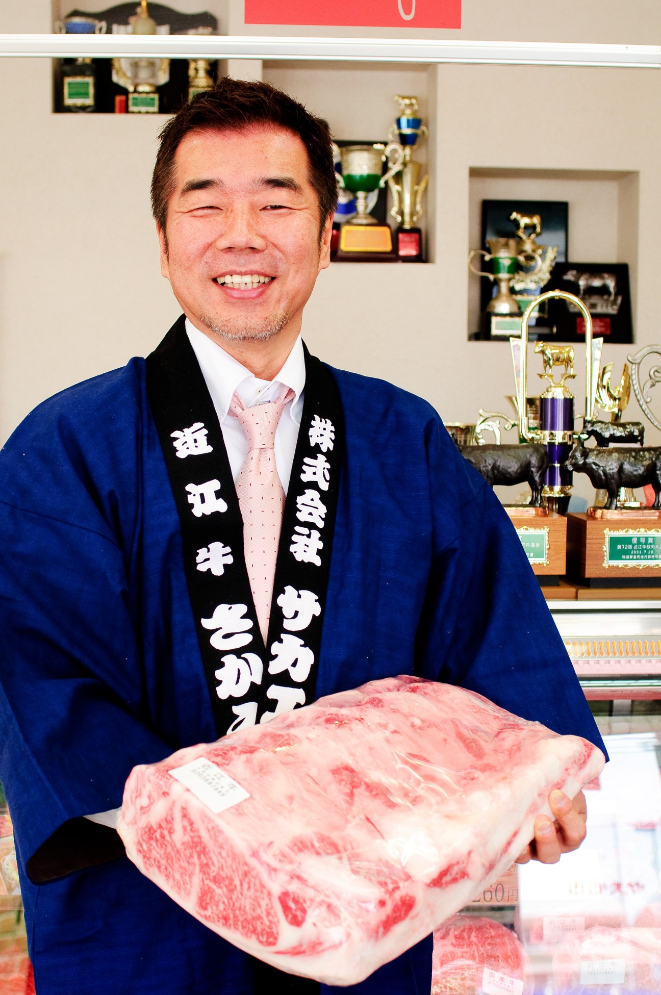 Yoshinobu Niiho, owner of Sakaeya butchers, holding marbled Omi beef in his shop.