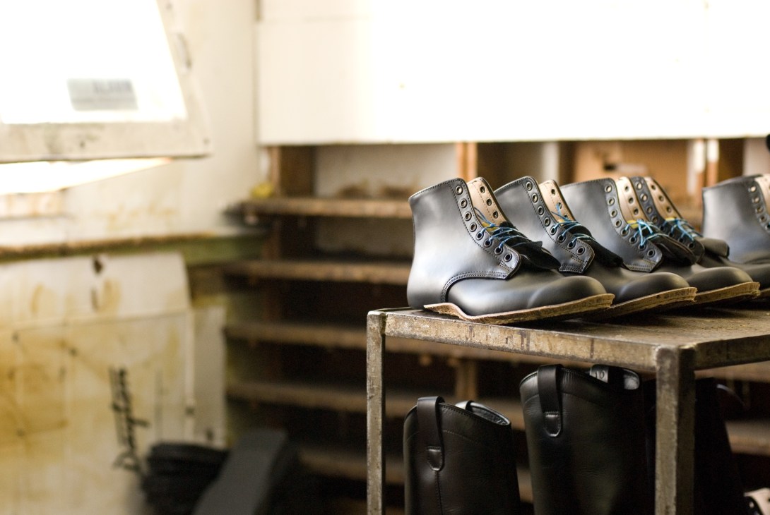 Almost finished Dayton boots lined up on a work table in the factory.