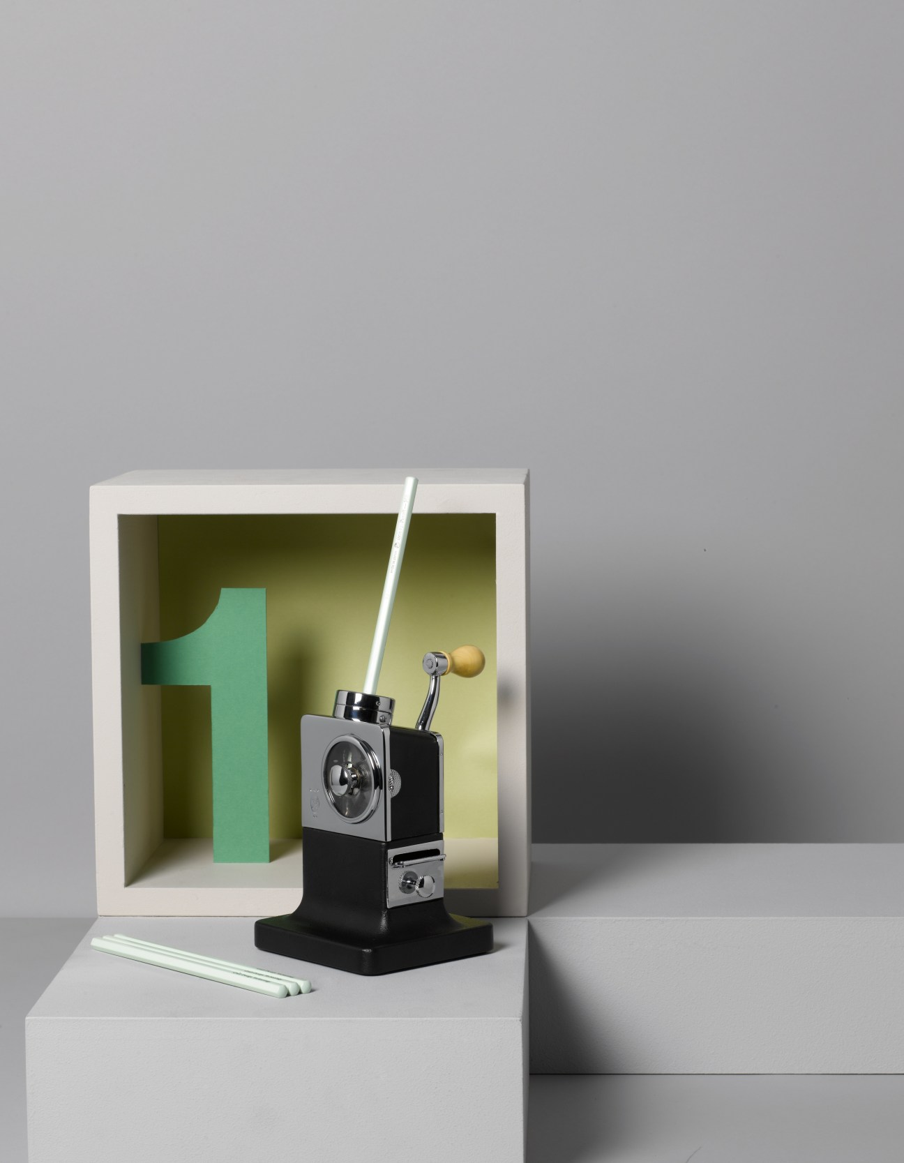 El Casco pencil sharpener with black base and chrome details displayed with green pencils.
