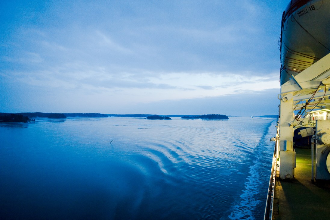 Early morning view from M/S Gabriella ferry showing calm Baltic Sea waters and distant forested islands under blue sky.