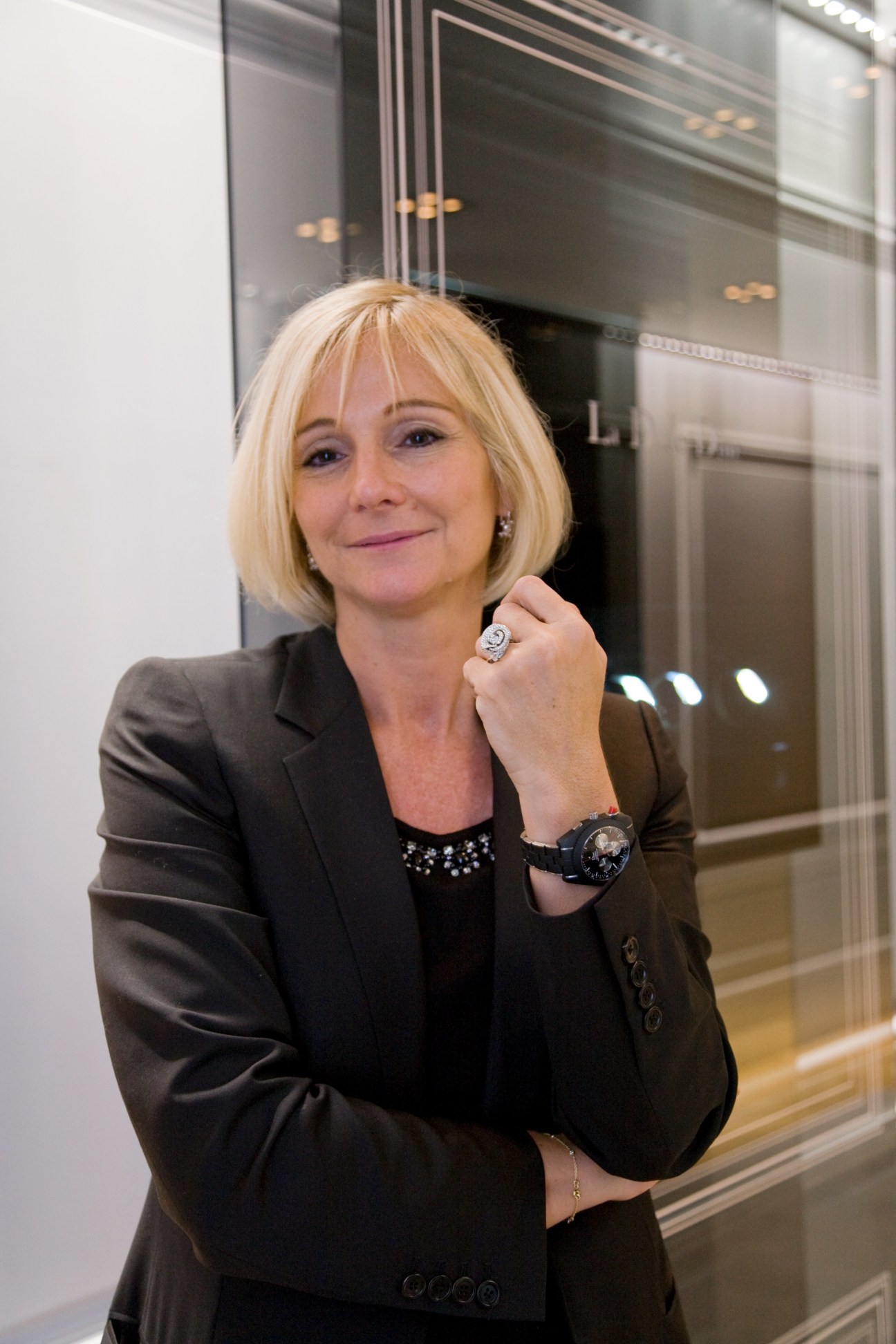 Laurence Nicolas, president of Dior Montres, poses wearing a dark blazer and displaying a luxury watch on her wrist.