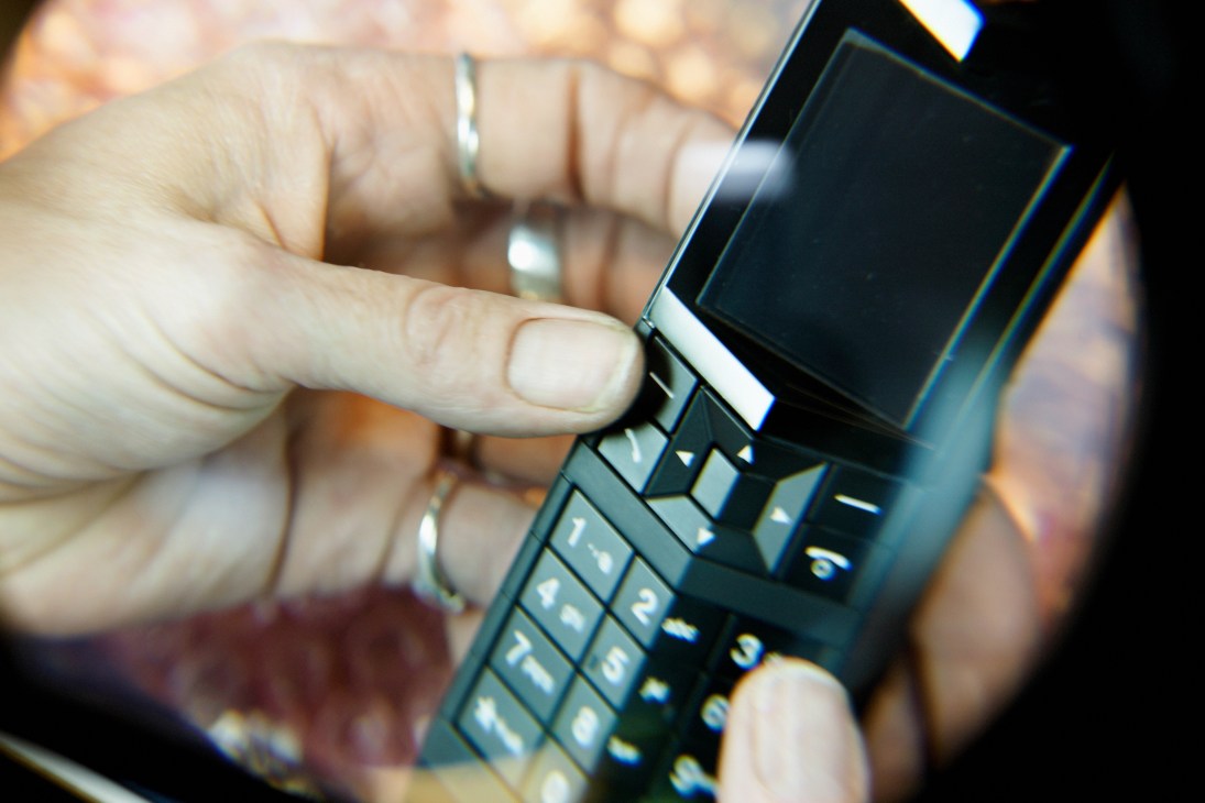 Hands holding an IP handset with display screen and numeric keypad