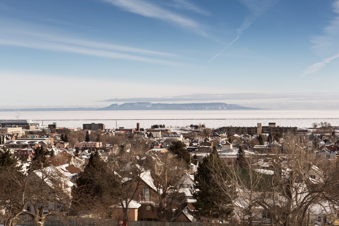 Aerial view of Thunder Bay with frozen lake and Sleeping Giant formation in distance