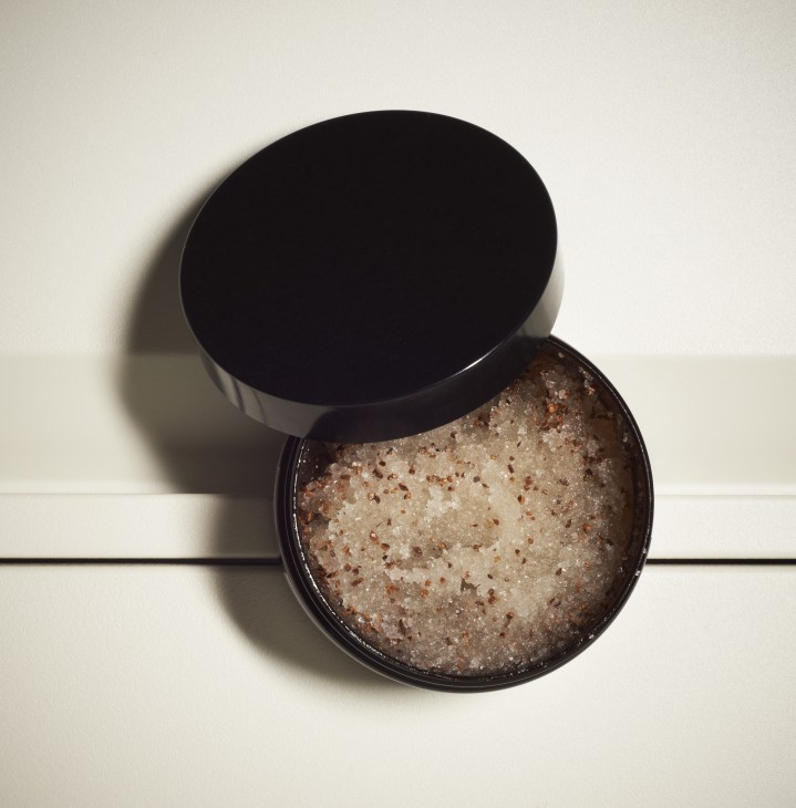 Mitchell and Peach body scrub in black container with lid, showing granular texture inside.