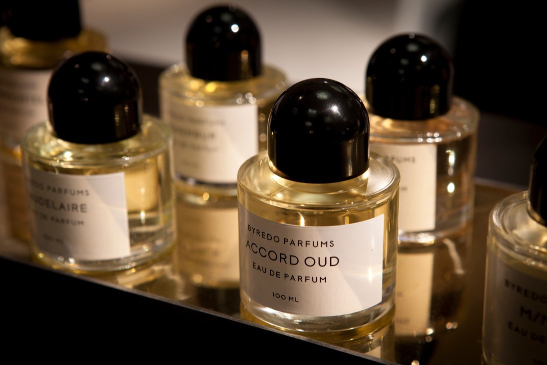 Byredo Accord Oud perfume bottle with black cap among other fragrance bottles on display.