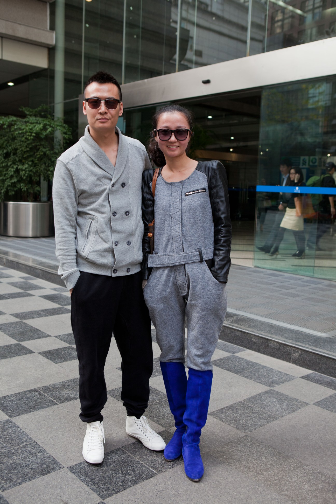 Young couple wearing sunglasses standing outside Times Plaza in Chengdu