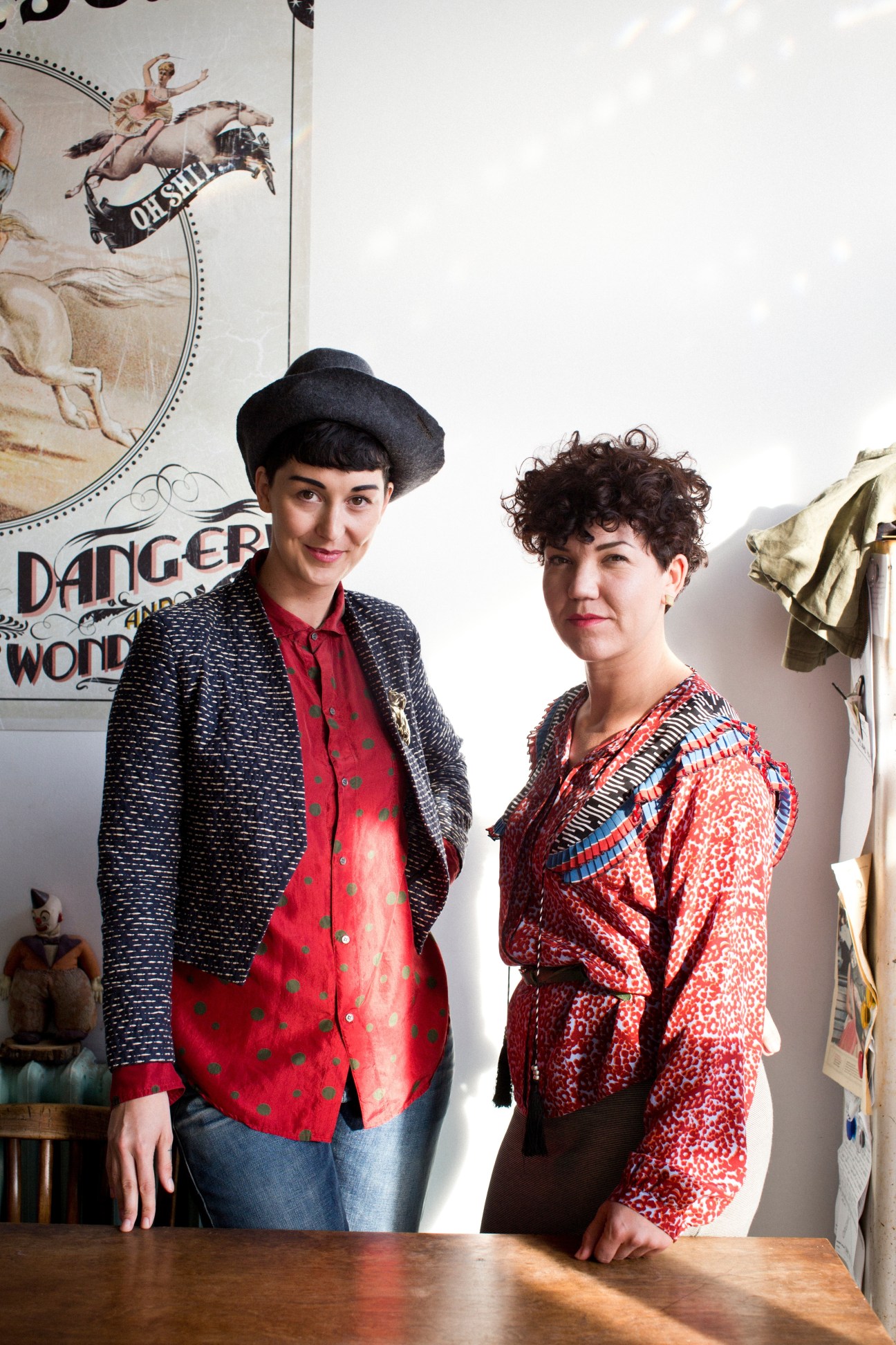 Kerry Butt and Meg Watson stand in their Toronto boutique, The Future of Frances Watson, with vintage signage visible behind them.