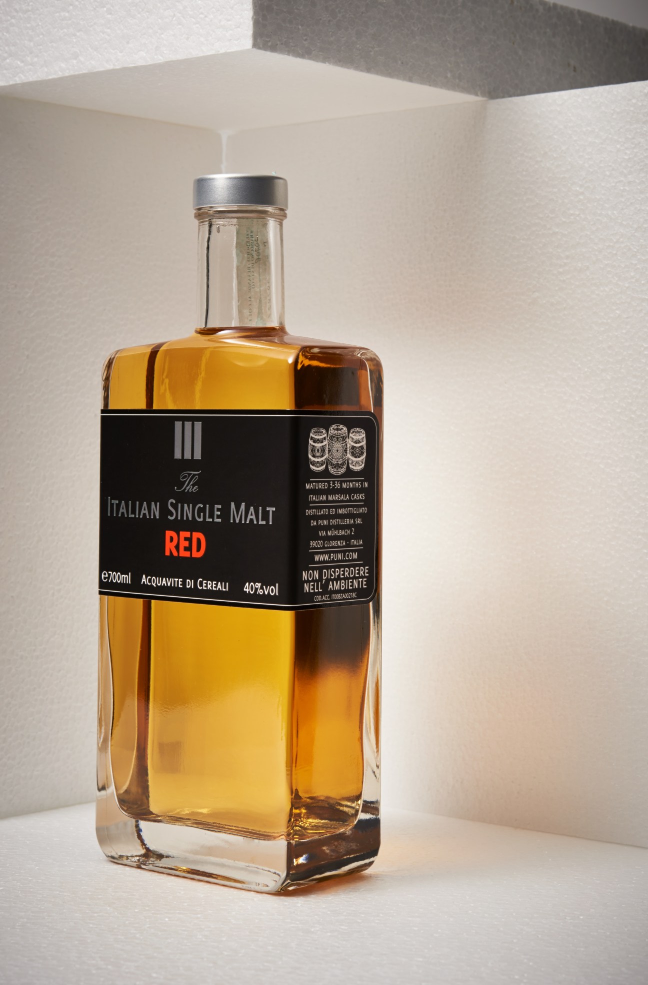 Puni Italian Single Malt Red whisky bottle with black label and silver cap.