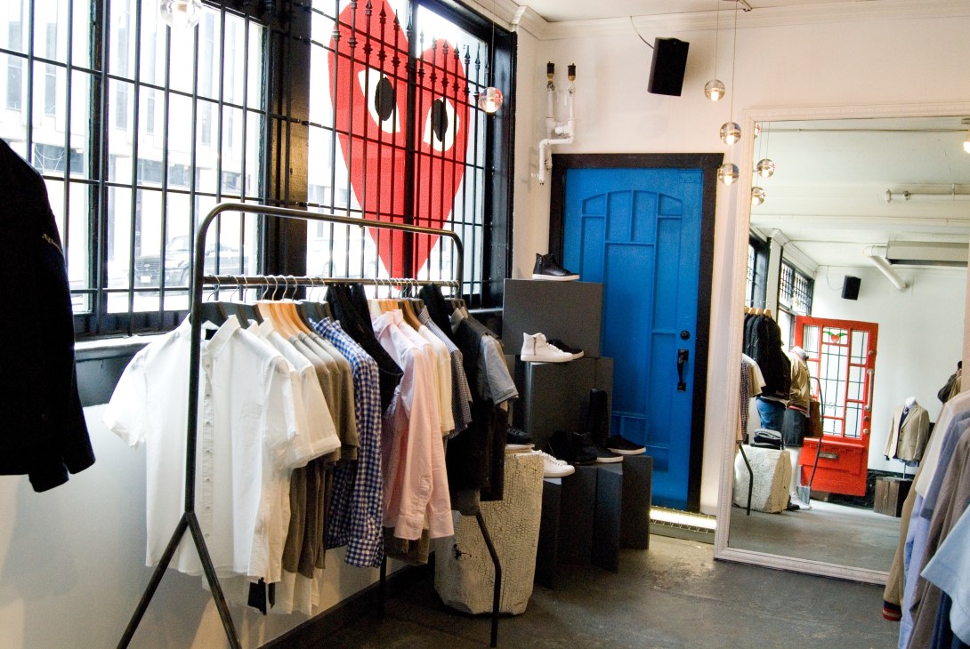 Roden Gray retail interior with clothing rack, blue door, and industrial-style windows.
