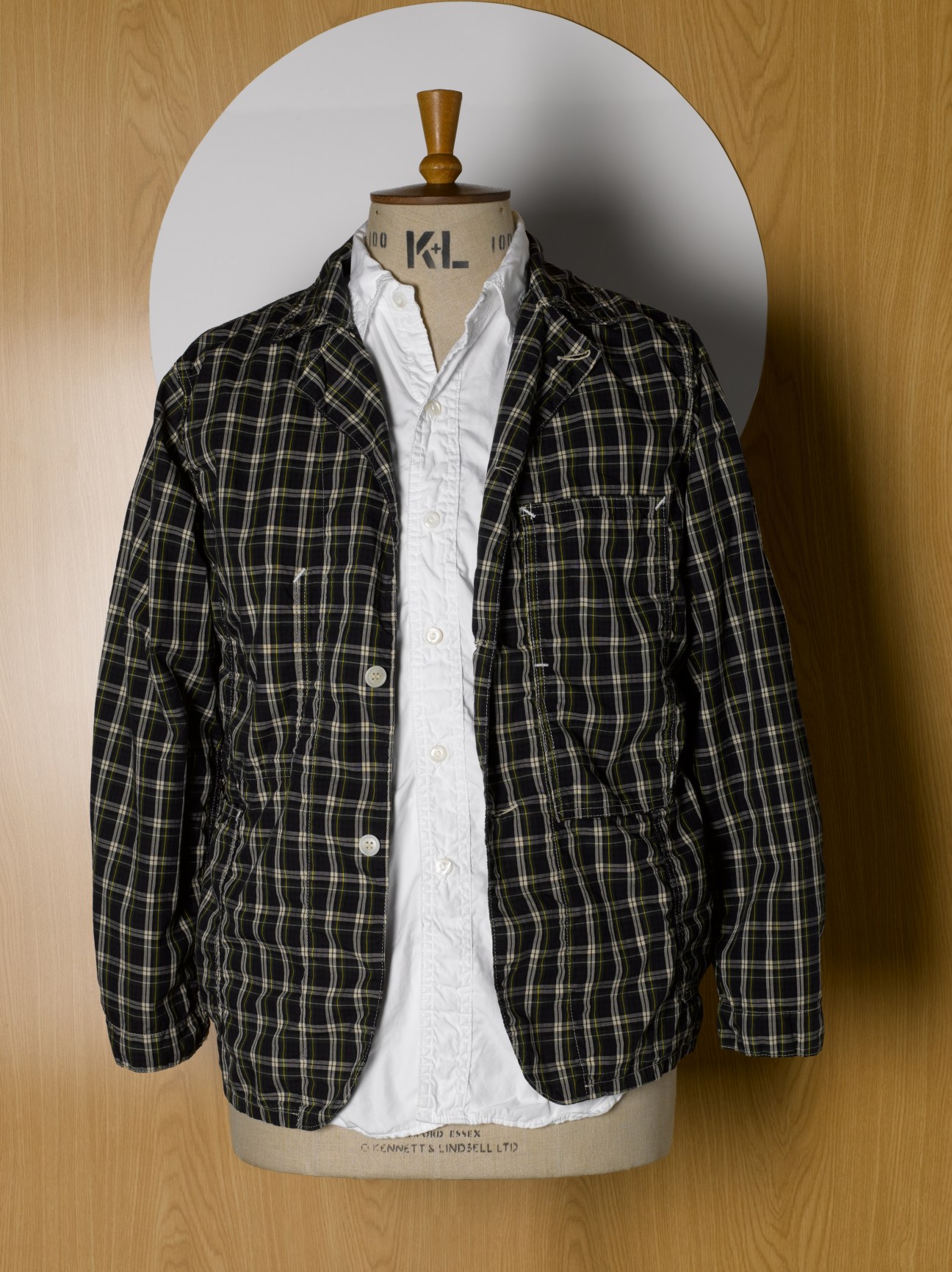 Black and white plaid jacket layered over a white shirt on a dress form mannequin.
