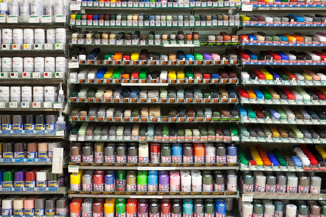 Shelves of paint cans and supplies in various colors at Tokyu Hands paint department.
