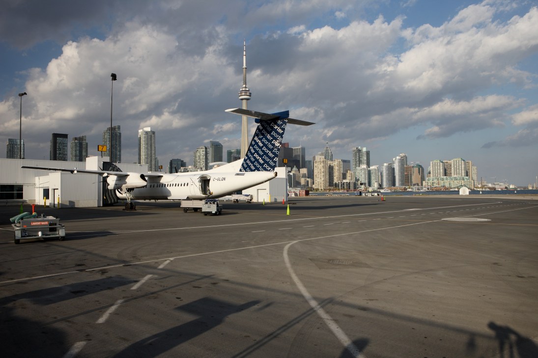 Porter Airlines aircraft parked at Billy Bishop Airport with Toronto skyline in background.