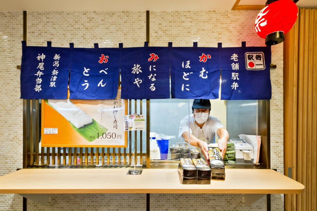 Ekibenya Matsuri bento box vendor counter at Tokyo Station with Japanese signage and displayed meal boxes.