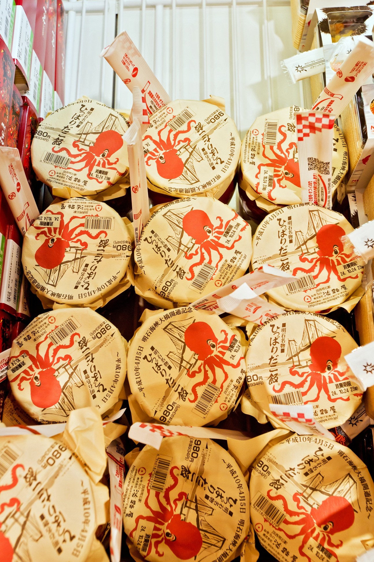 Japanese bento box packages with red octopus design and Japanese text labels at Ekibenya Matsuri station shop.