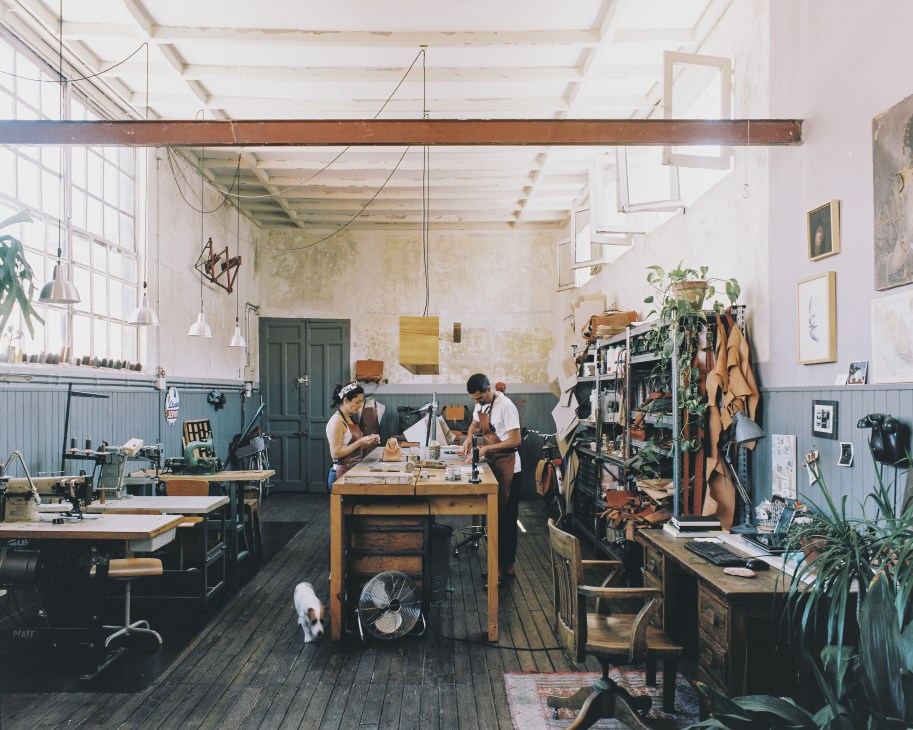 David Iglesias Resina and Melina Carranza Maciel work in their leather studio with their dog Pedales in Madrid.