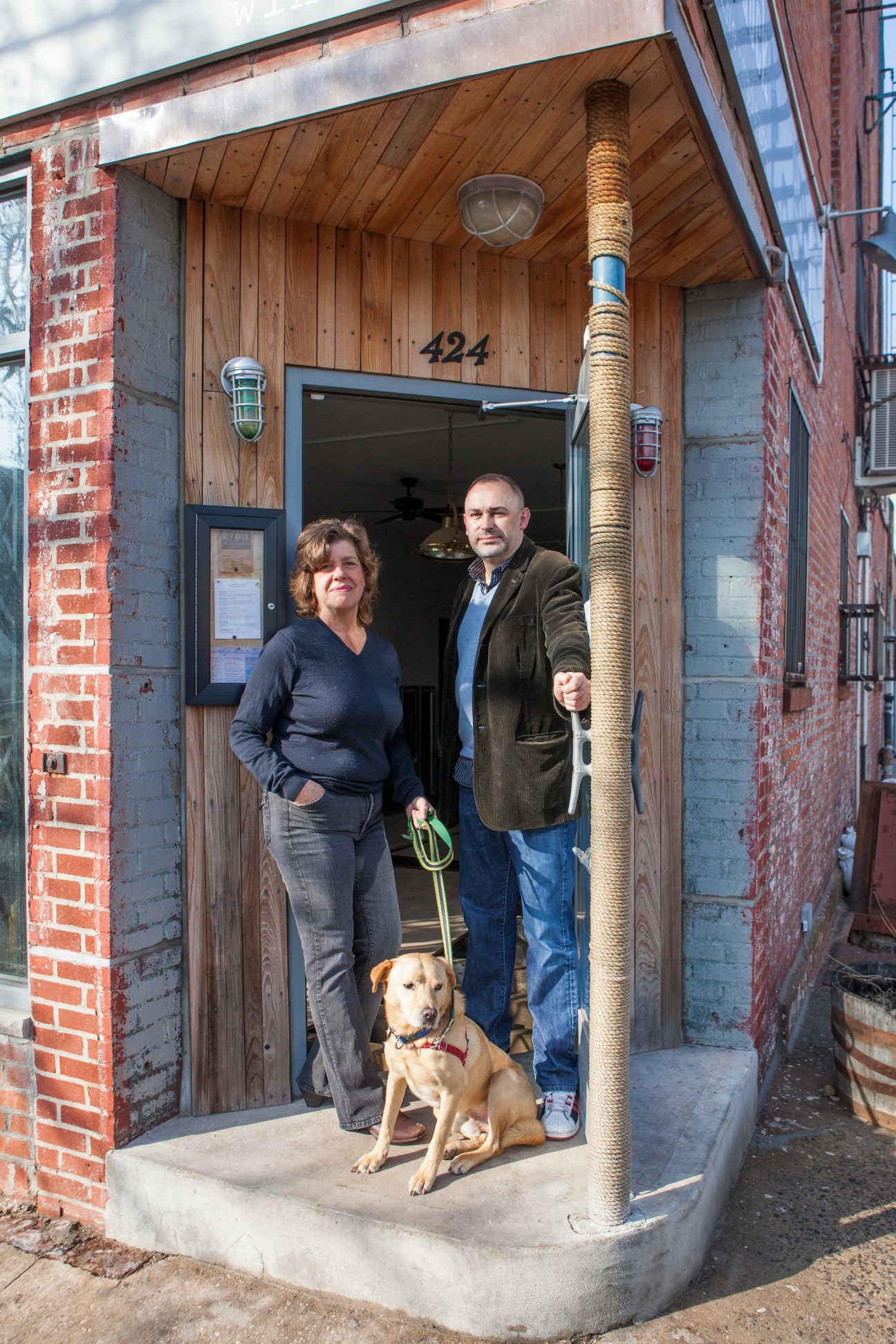 Ron and Mary Kyle stand in the doorway of their home with their dog in Red Hook, Brooklyn.